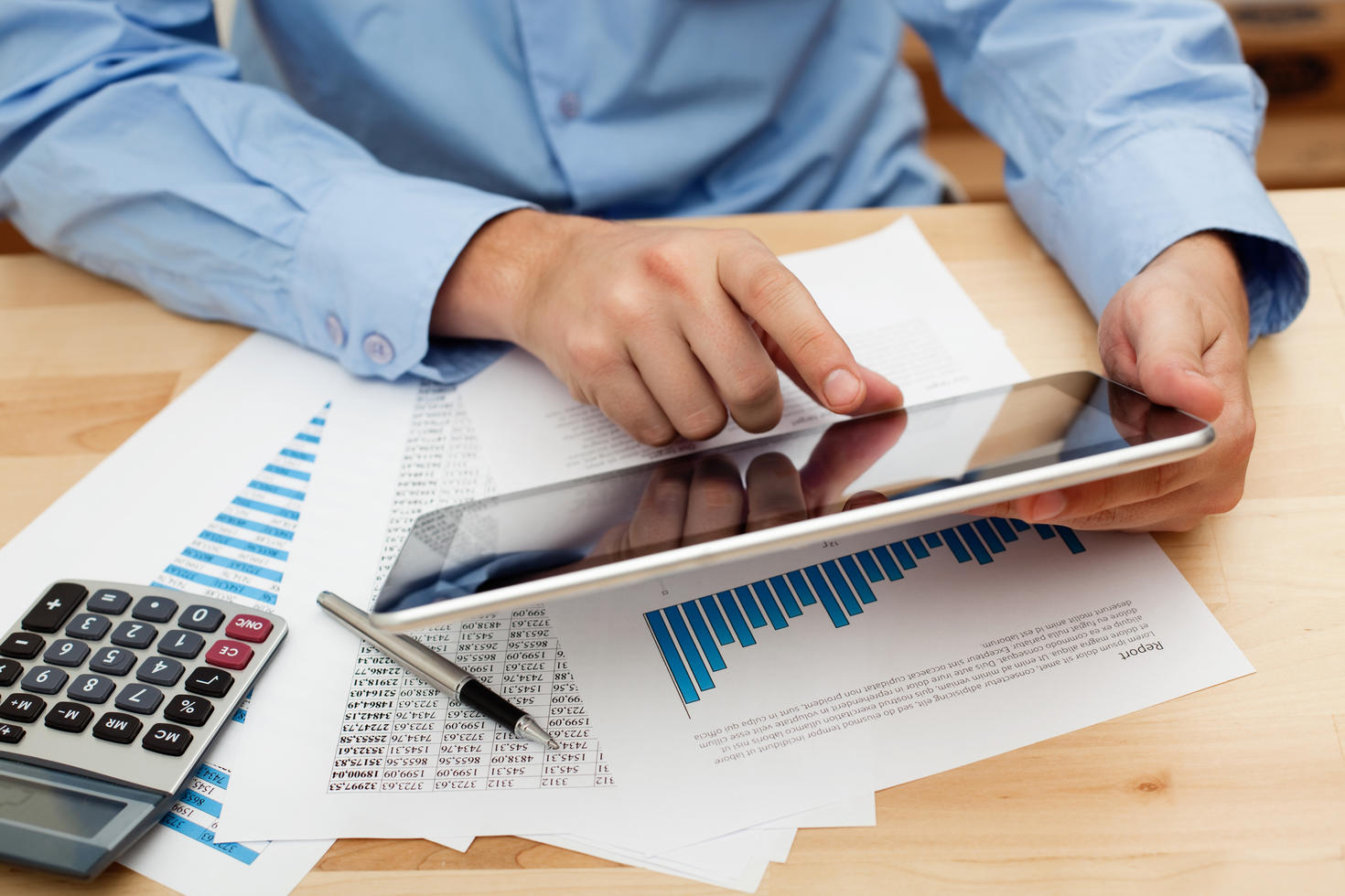Man working on calculator and graphs
