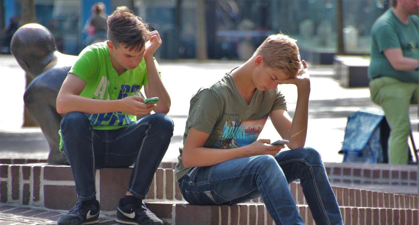 Two young men on cell phones