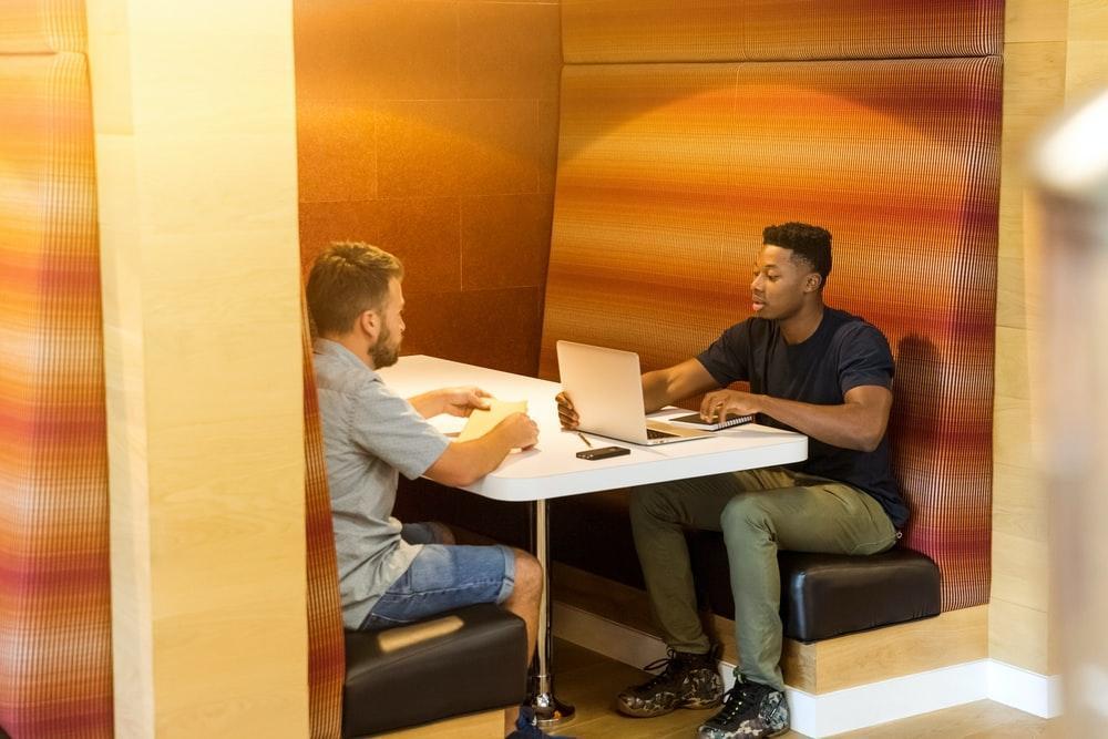 two students sitting across from each other at a table