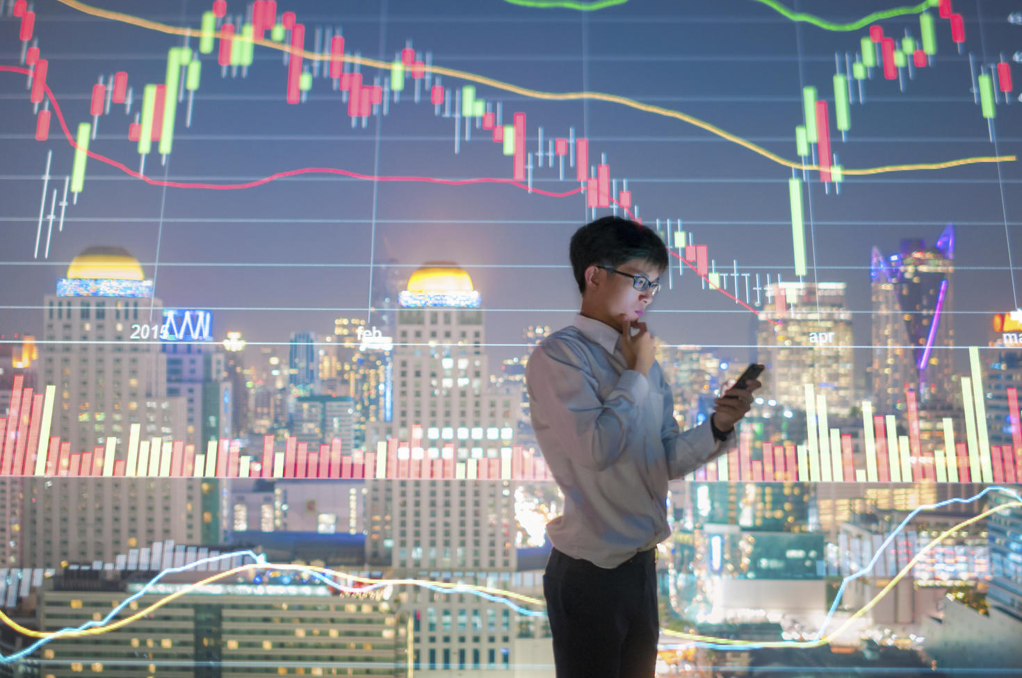 Man on phone with city and graphs in the background