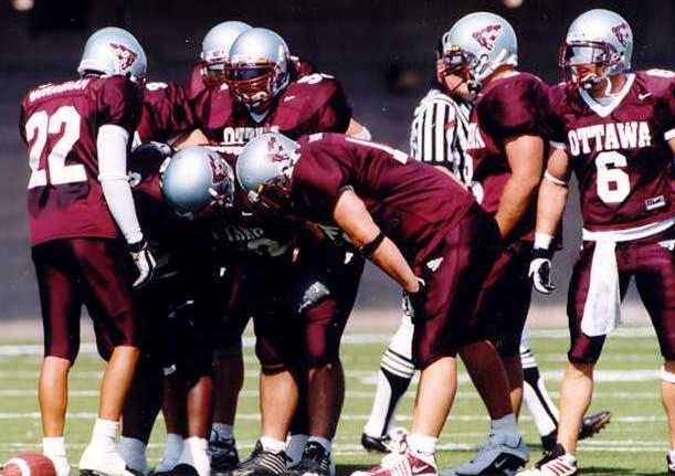 gee-gees football players in a huddle