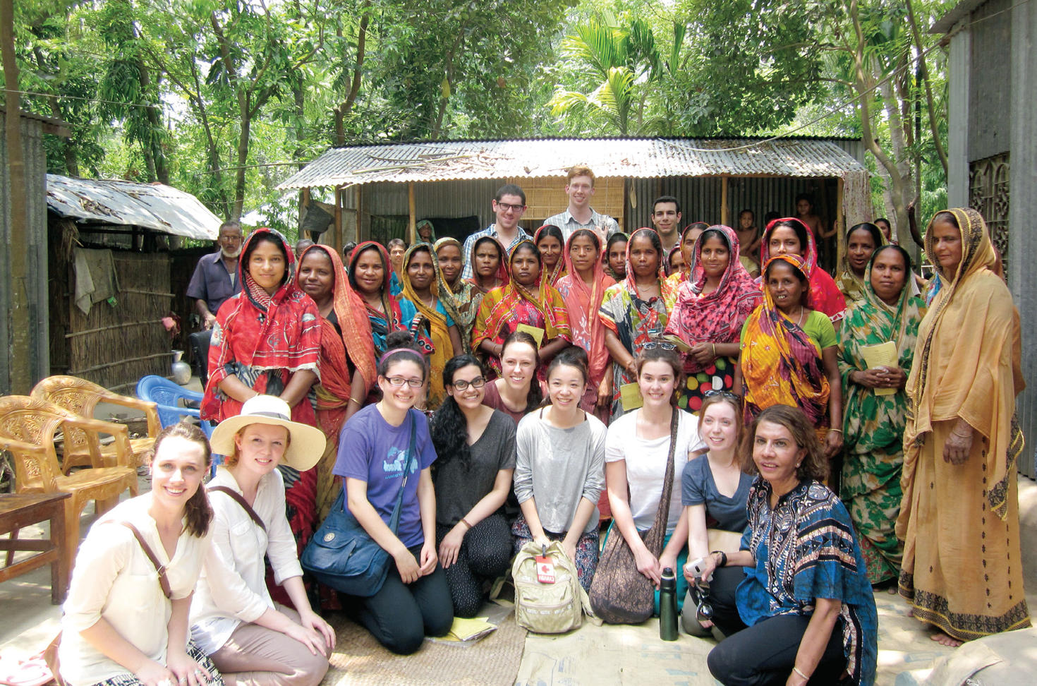 Photo taken during an international exchange, group photo includes University of Ottawa students along with locals and organization members in a South East Asian village.