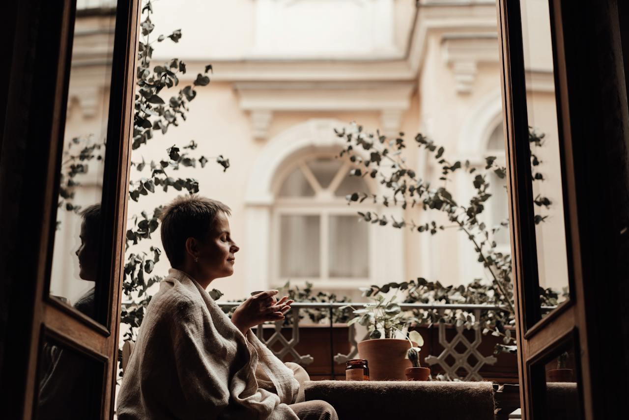 A person sitting on a couch looking out a window