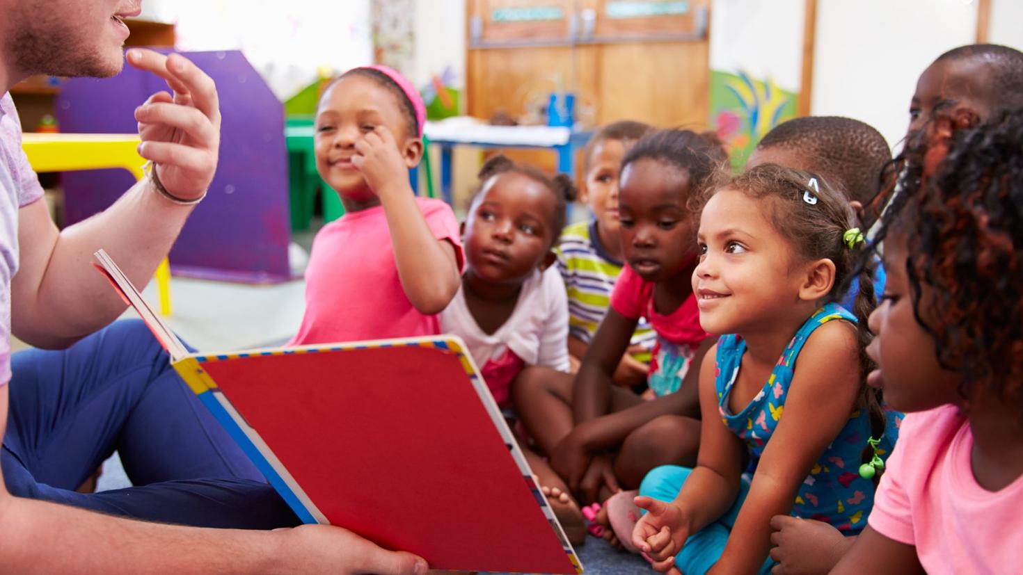 Group of students in front of teacher reading a story 