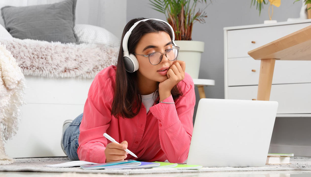 A girl on her laptop with headphones on