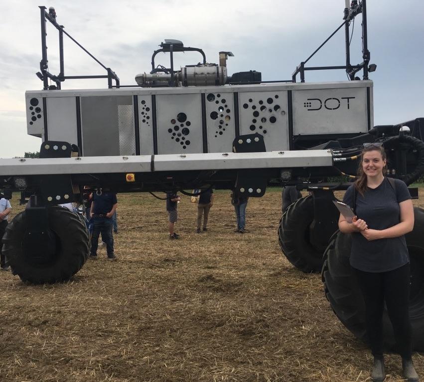 une femme debout devant de l'équipement agricole