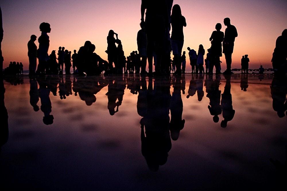 Silhouettes de personnes sur une plage.
