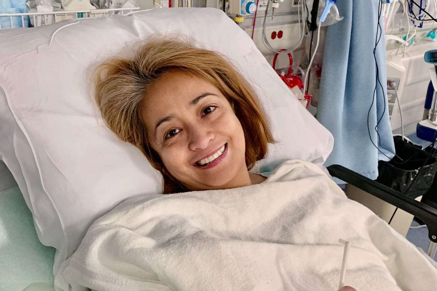 Une femme est allongée dans un lit d'hôpital.