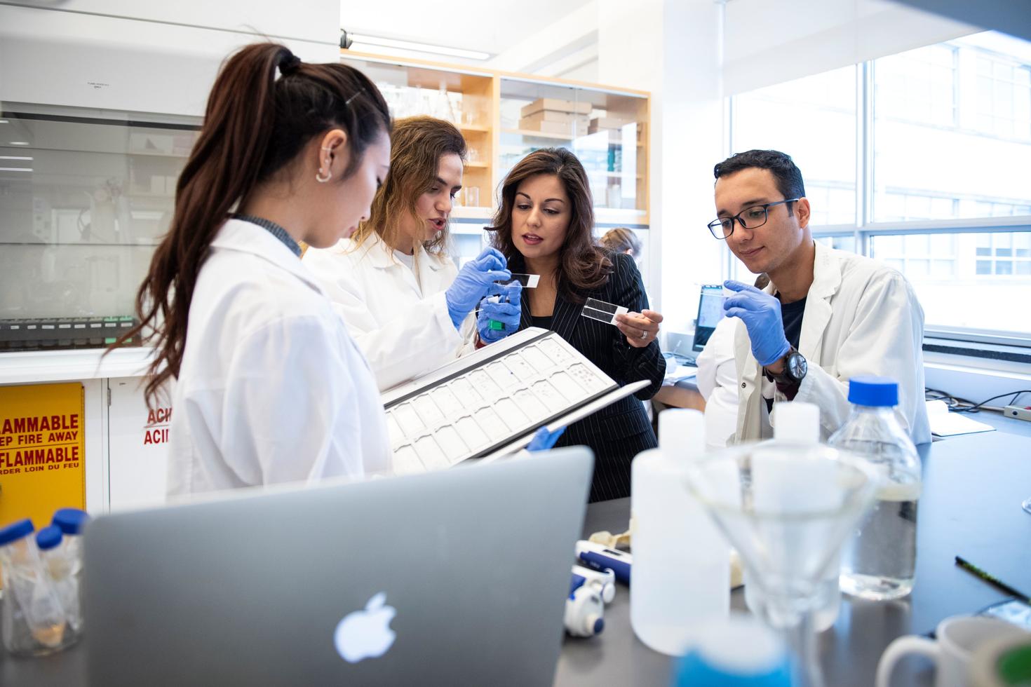 La Dre  Nafissa Ismail en compagnie de stagiaires examinant des échantillons au laboratoire.