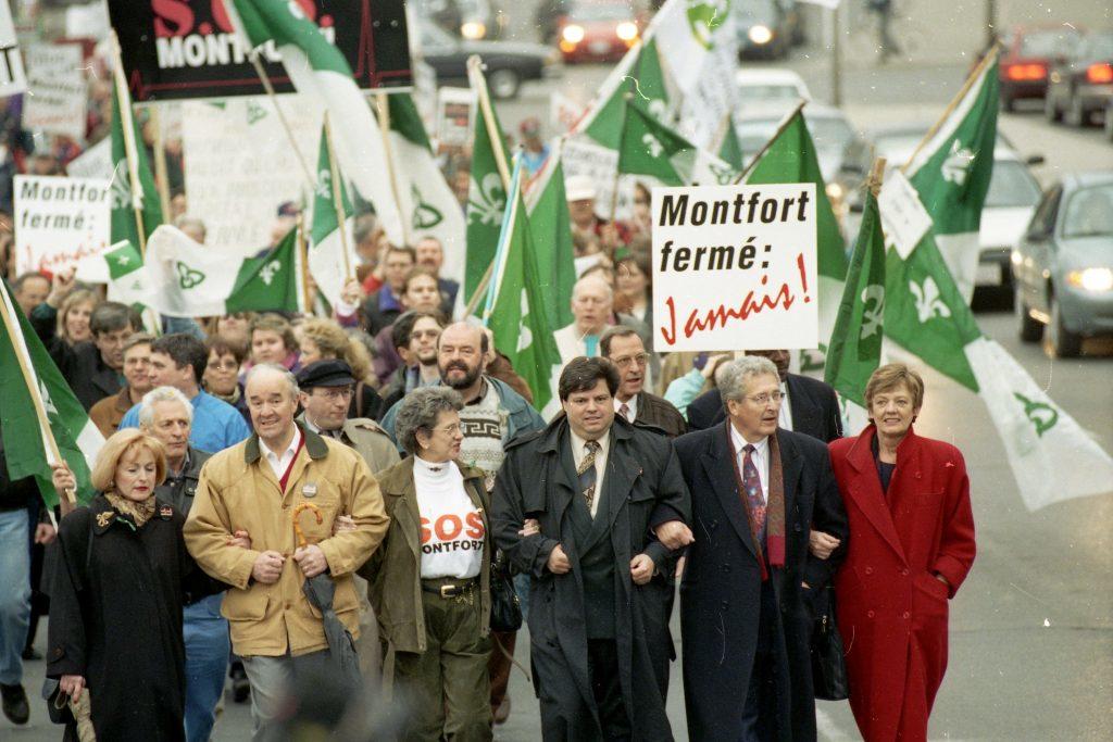 Groupe de personnes manifestant avec des banderoles et des drapeaux franco-ontariens
