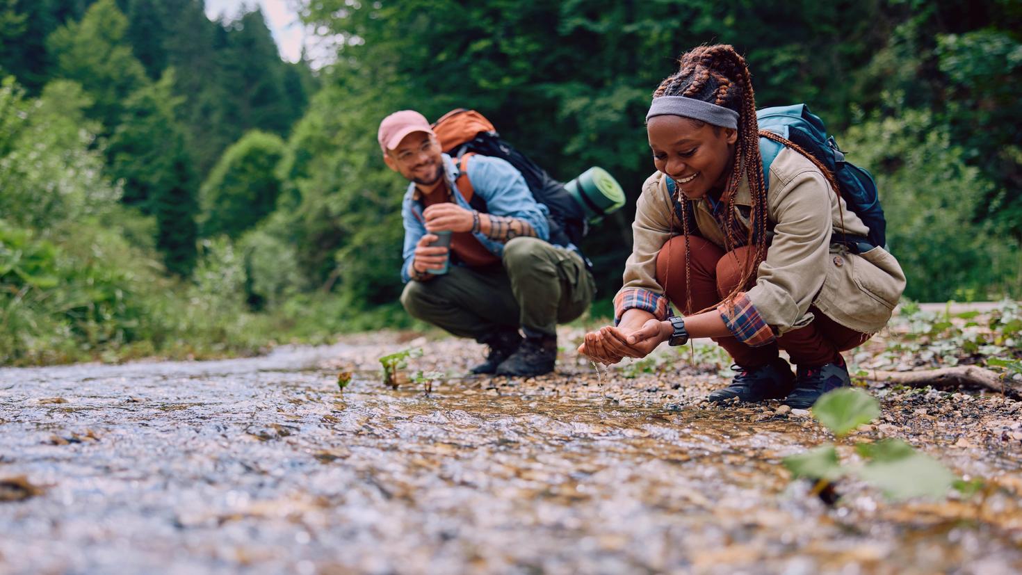 Two tourists with backpacks next to the water