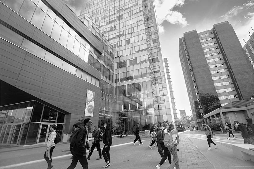 Des étudiantes et étudiants passant devant le bâtiment des sciences sociales de l'Université d'Ottawa. 