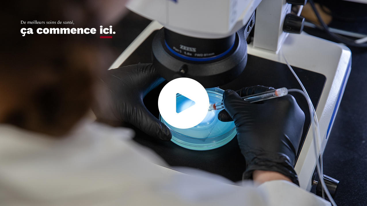 vue par dessus l'épaule d'une personne qui regarde un échantillon au microscope