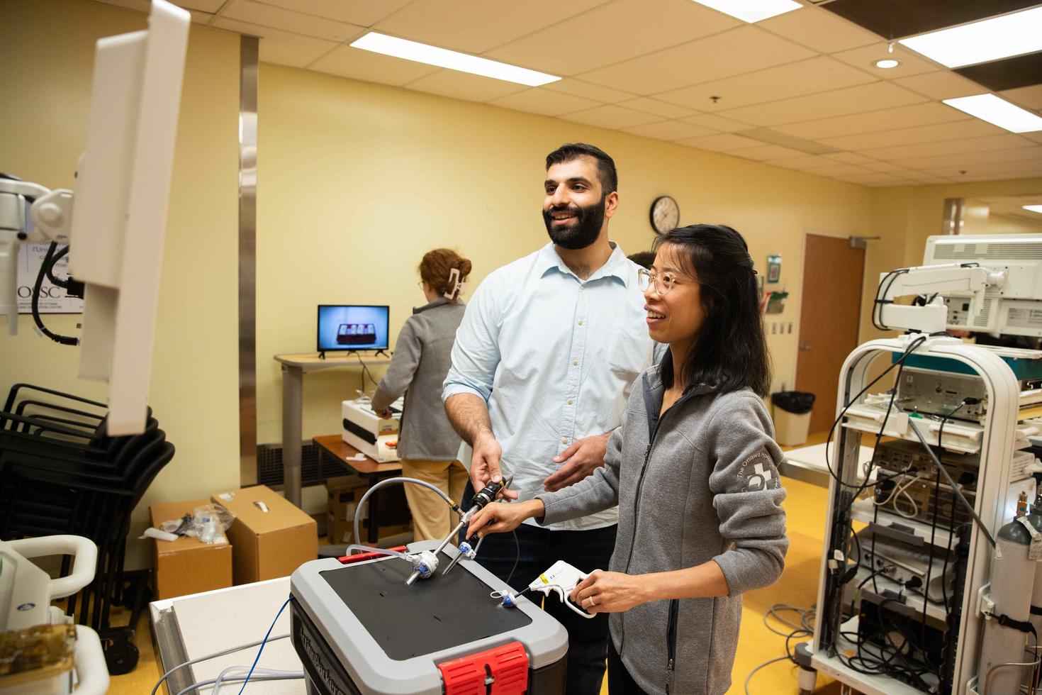 Un professeur et une étudiante devant une machine de simulation