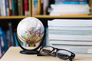 Globe terrestre, lunettes et livres dans la bibliothèque.