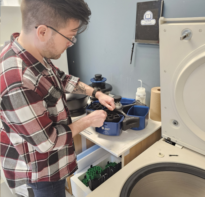 Un étudiant qui utilise une machine centrifuge.