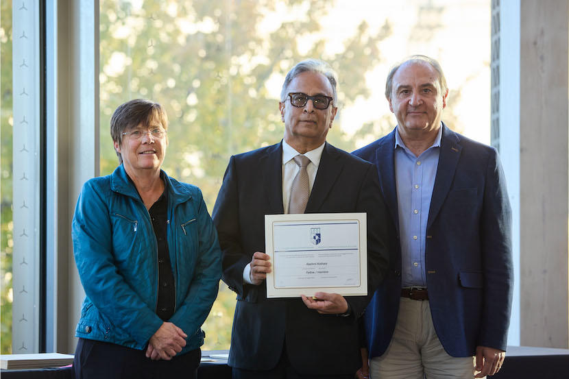 Dr. Rashmi Kothary holding a certificate alongside leaders of CAHS.