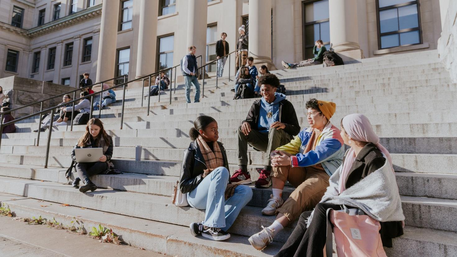 Des étudiants assis sur les marches de Tabaret