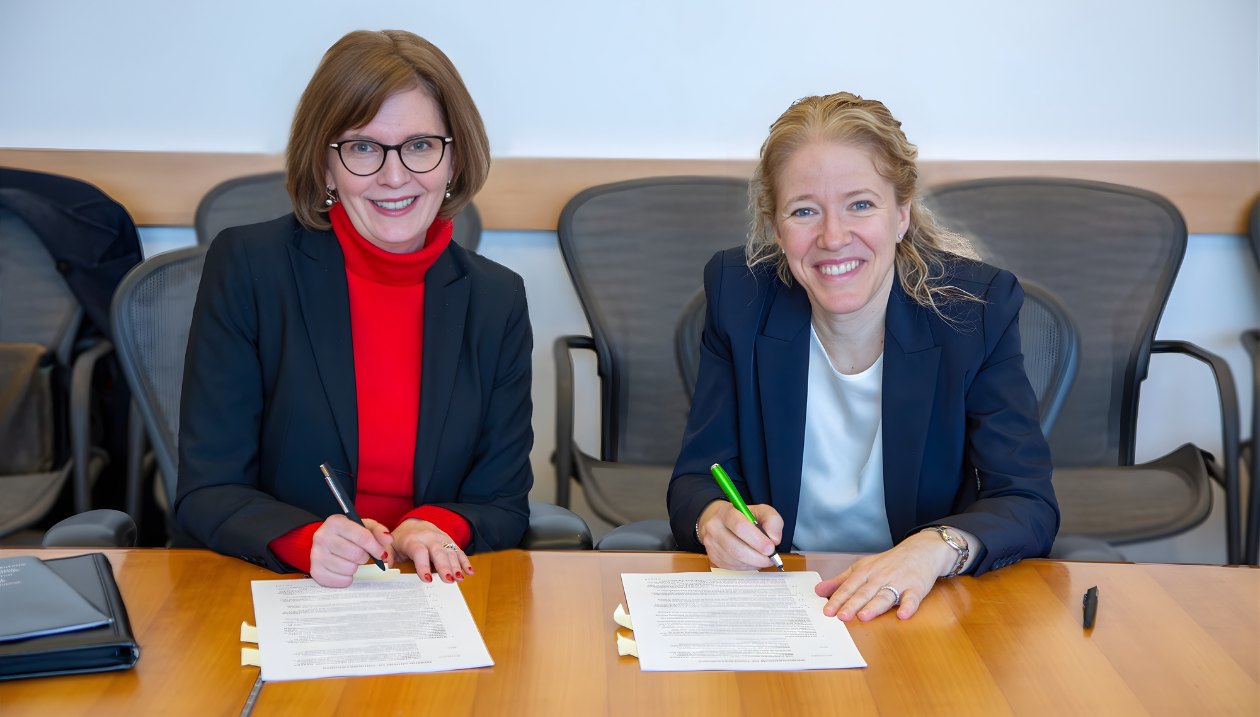Susan Farrell, PDG de l'ACSM Ottawa, à gauche, et Julie St-Pierre, vice-rectrice à la recherche et à l'innovation, à droite, qui signent un document. 
