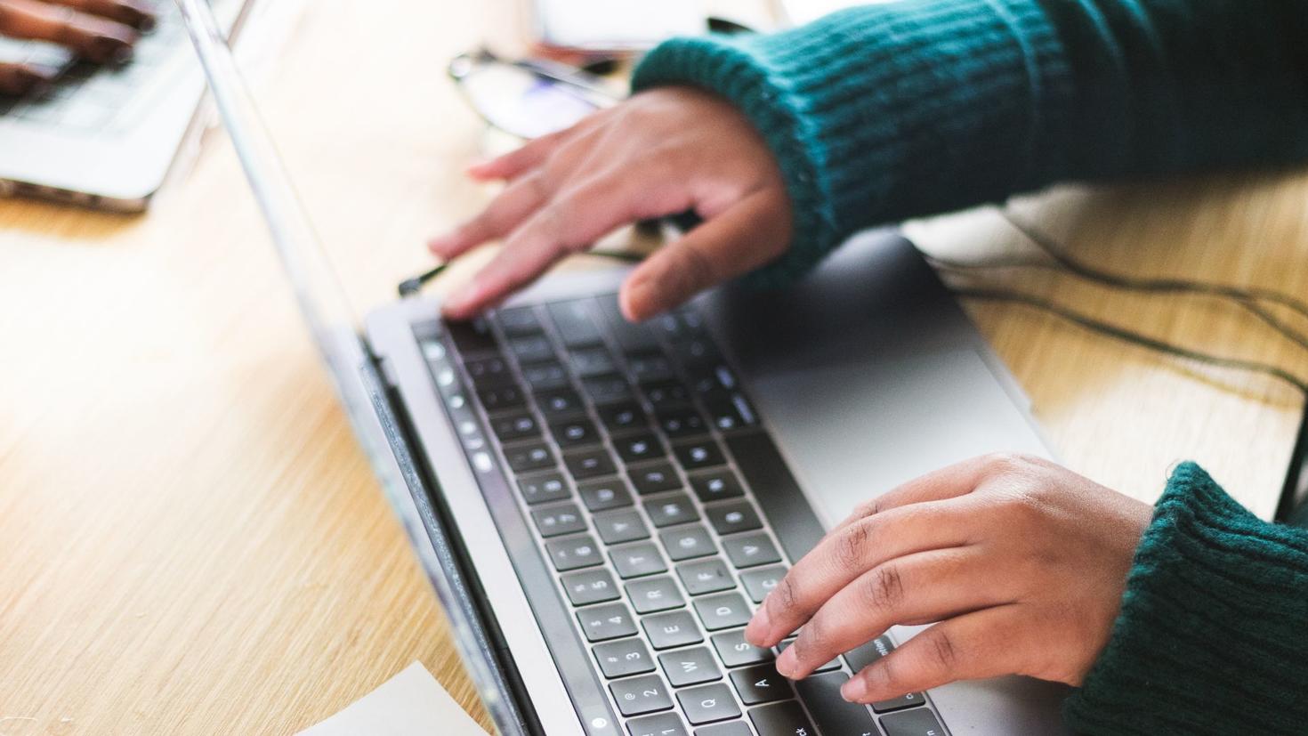 Student typing on laptop