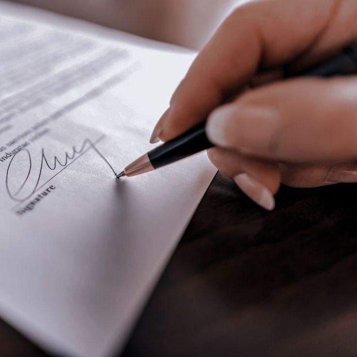 Une main signe un contrat