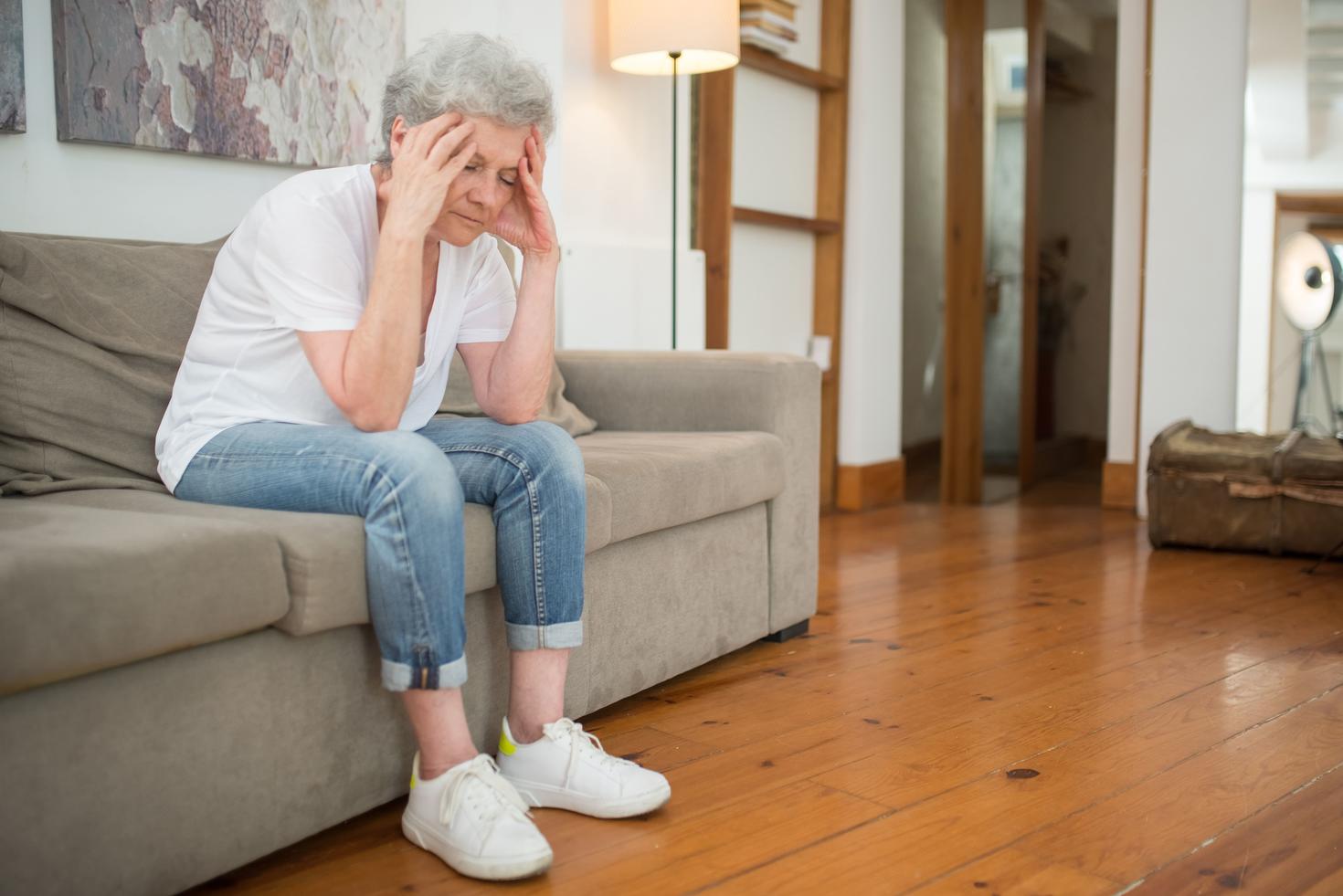 Une personne âgée se tenant la tête.
