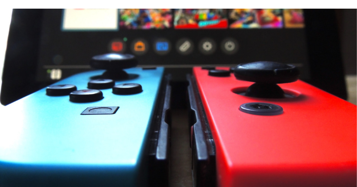 Deux manettes de Nintendo Switch avec un écran devant