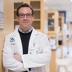 Researcher leaning on wall