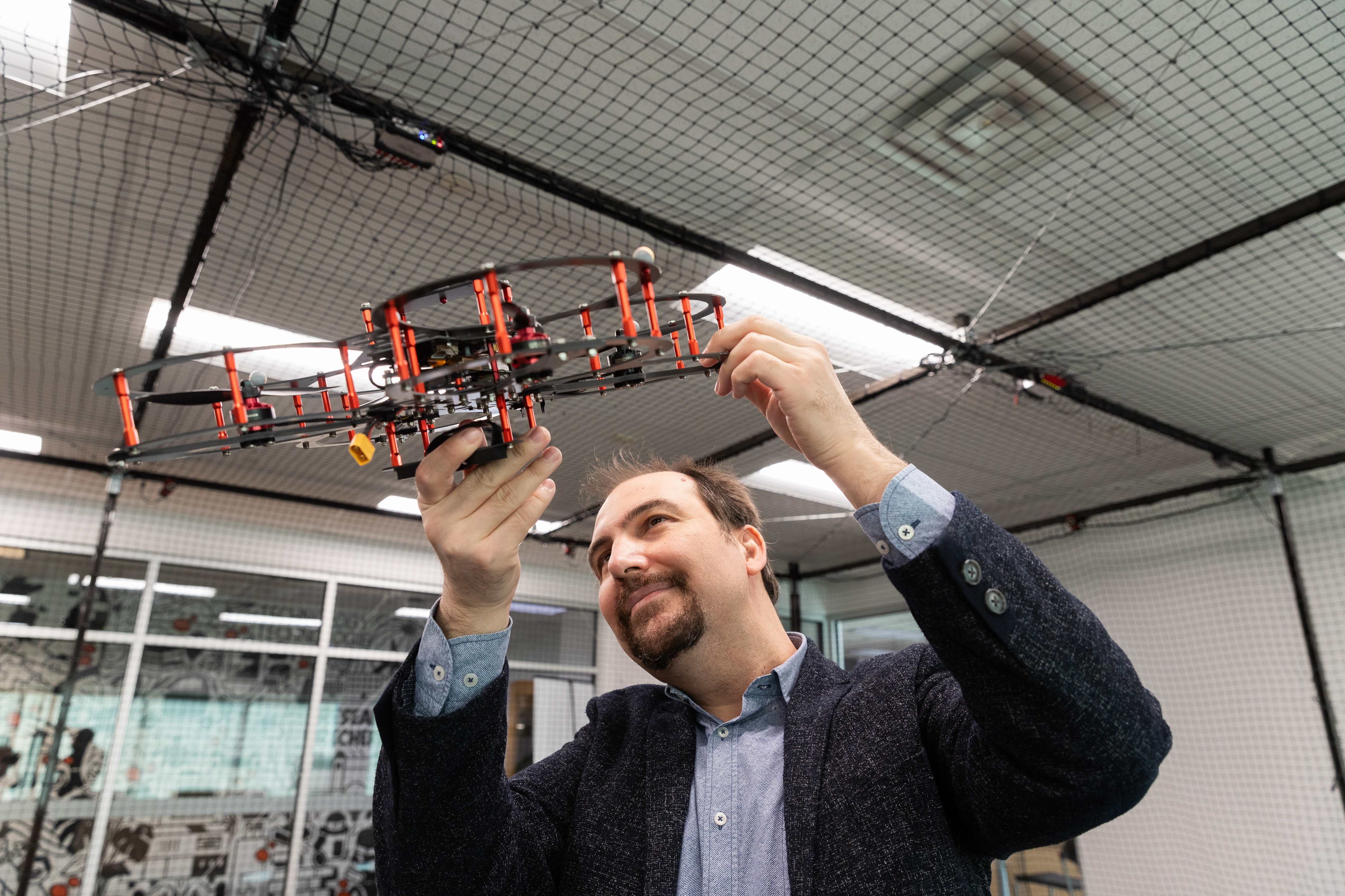 Professor Burak Kantarci holding up a drone