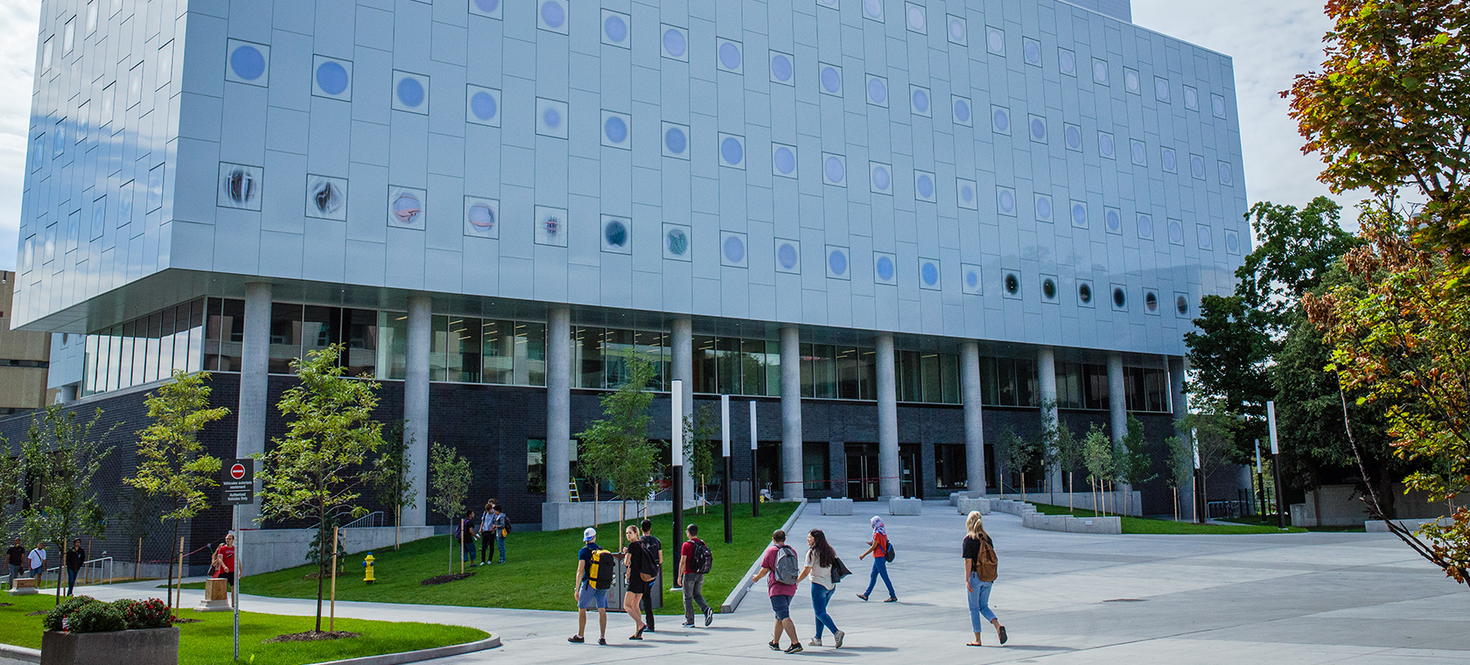 Exterior view of STEM complex with students walking in front of it