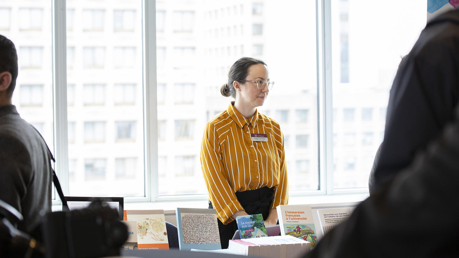 An employee presenting books at an event.
