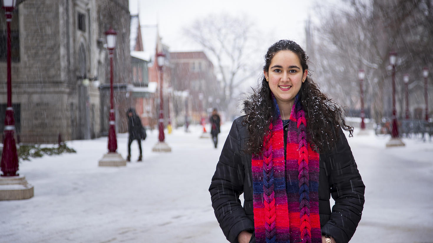 Parastoo stands in a street and snow is falling everywhere around her.