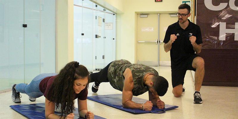 Two people making some workout with a personal coach.