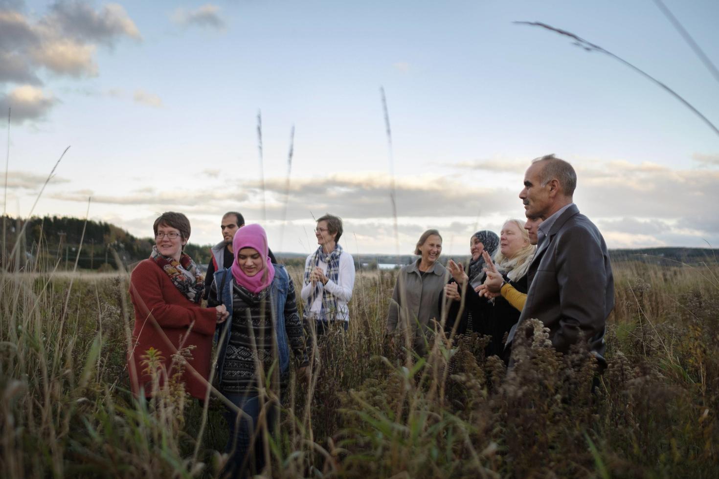 Group of people from various origins speaking in a field.