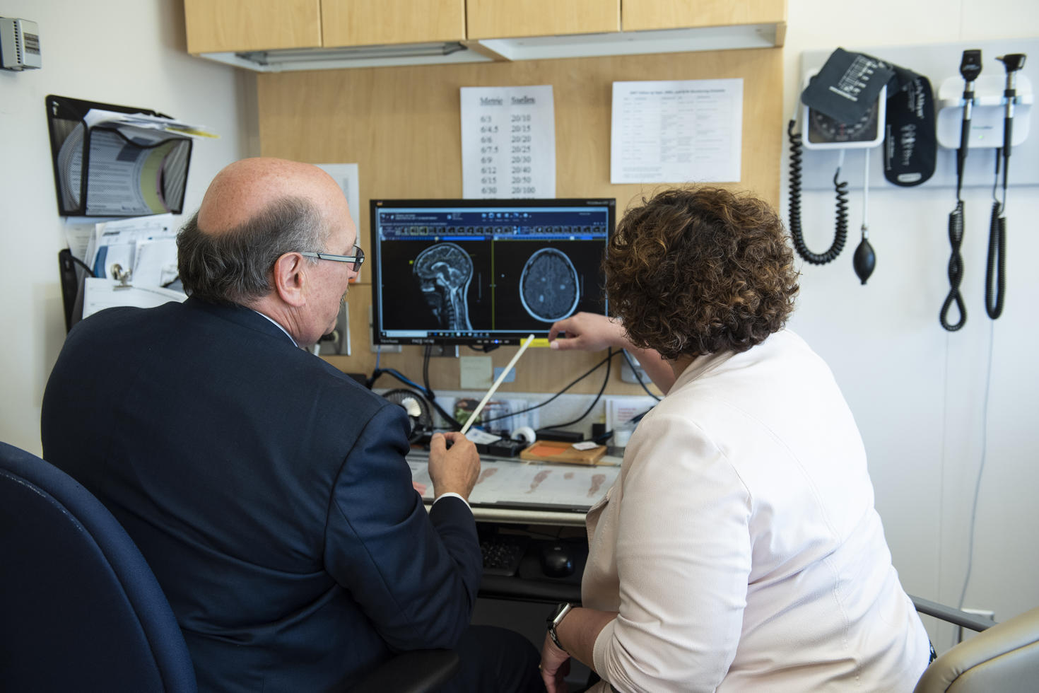 Two researchers analyzing brain scan on computer.