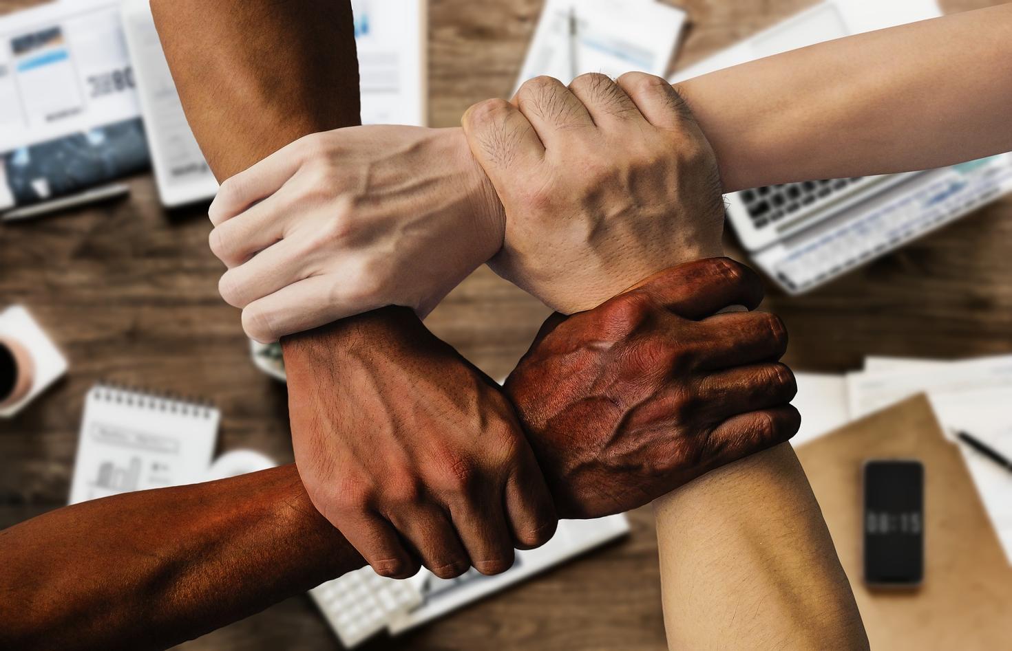 Four arms holding each other
