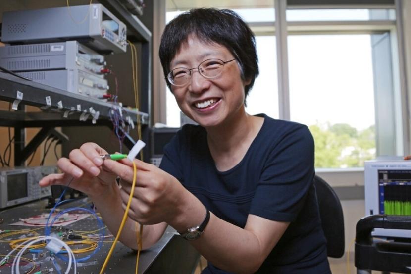 Professor Xiaoyi Bao working with cables in a lab