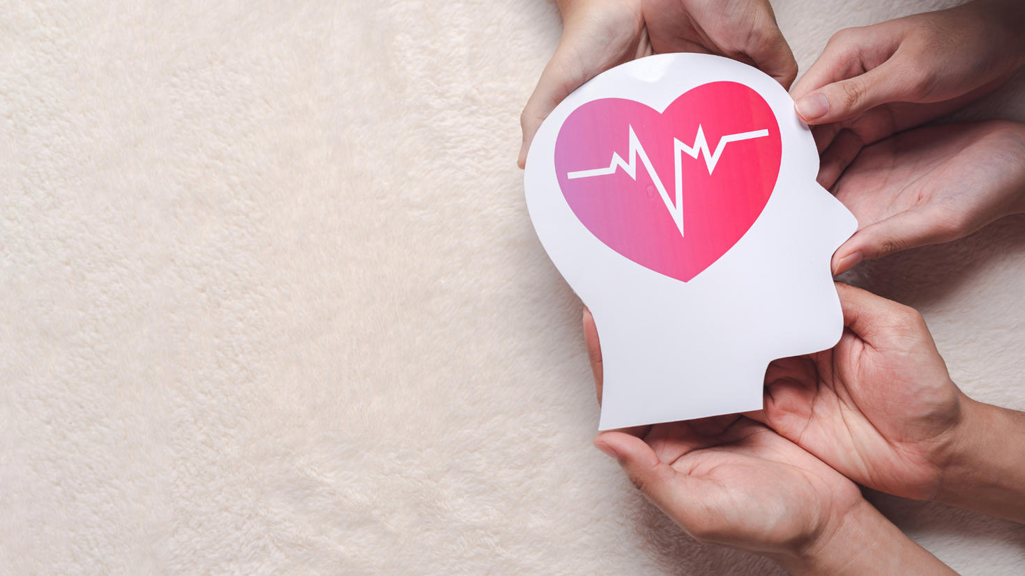 Hands holding a signage in the shape of a brain.