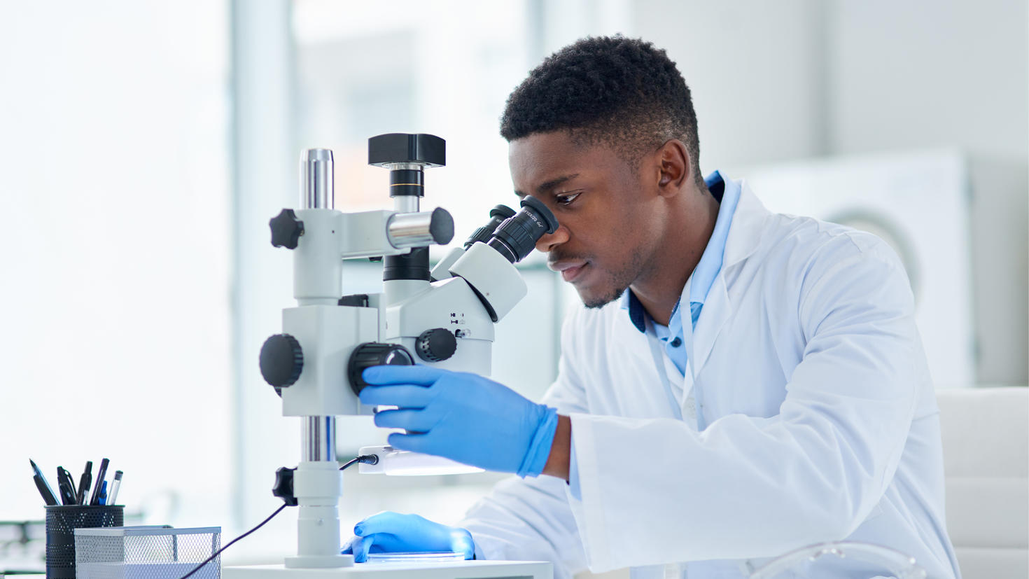 Male researcher looking in microscope