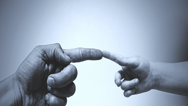 Adult and Child's hands connecting through a finger