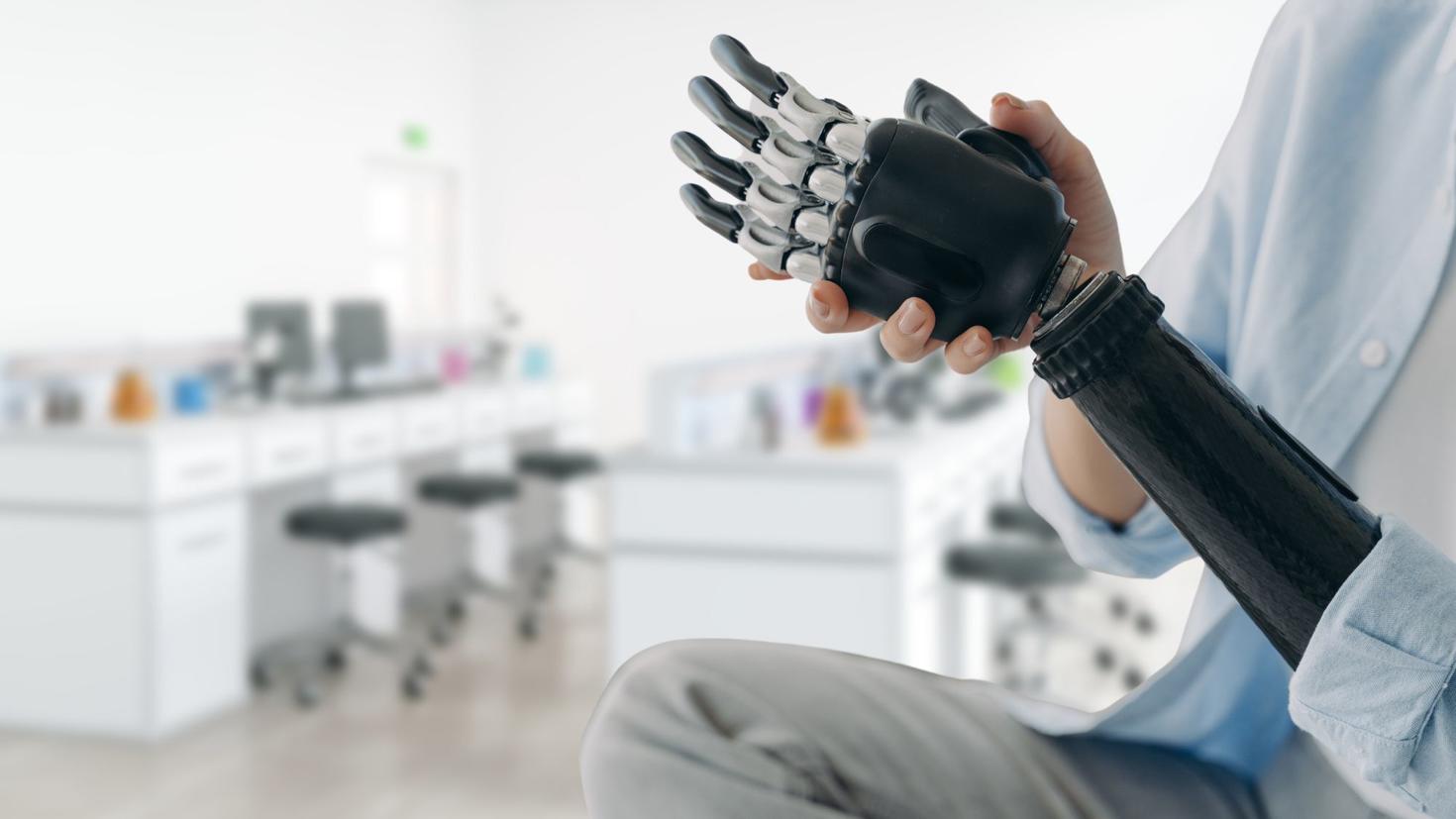 Person in a lab wearing a mechanical arm prosthesis