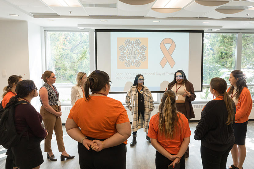 People in orange shirts stand in a circle