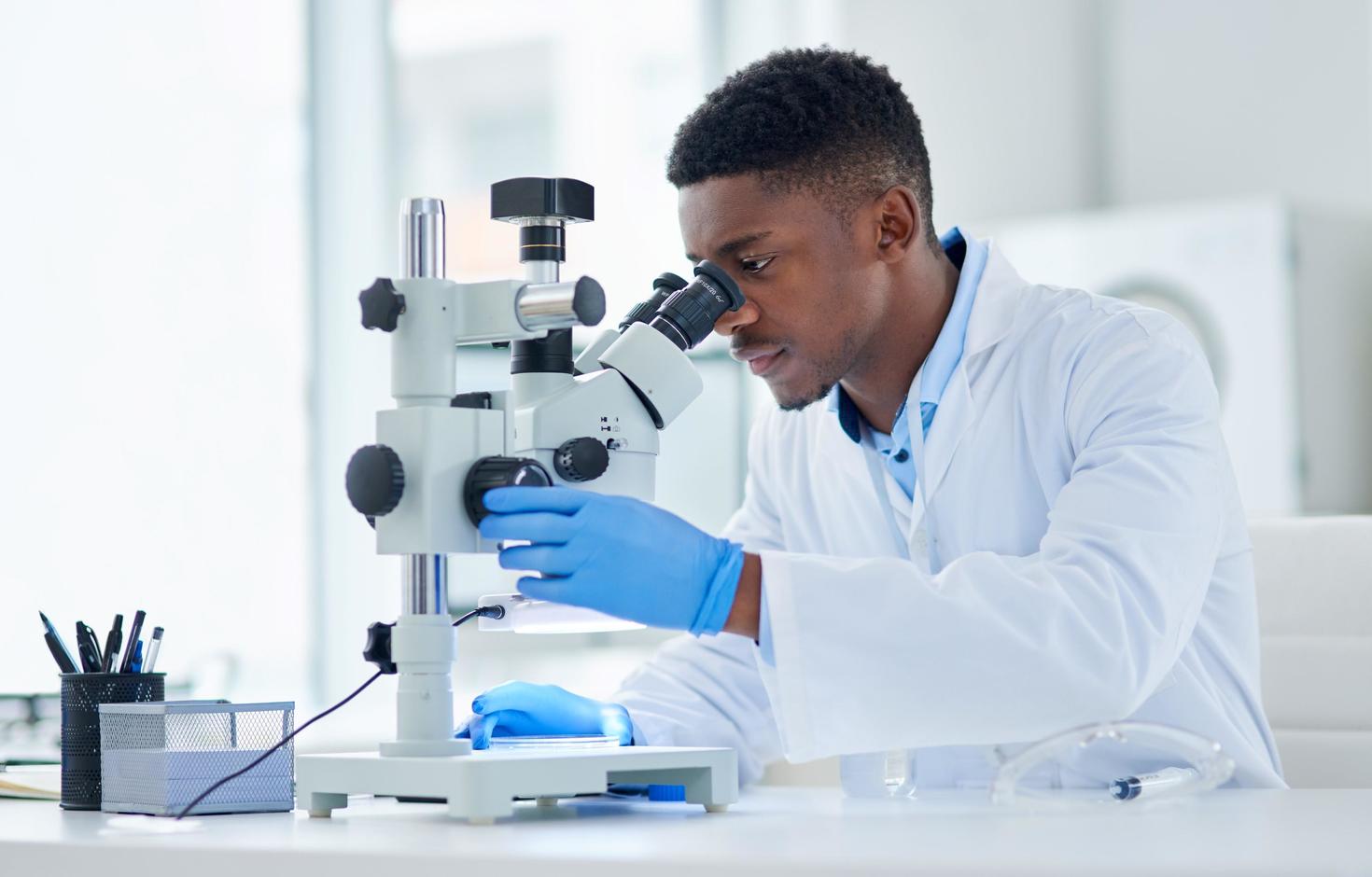 student-researcher using microscope