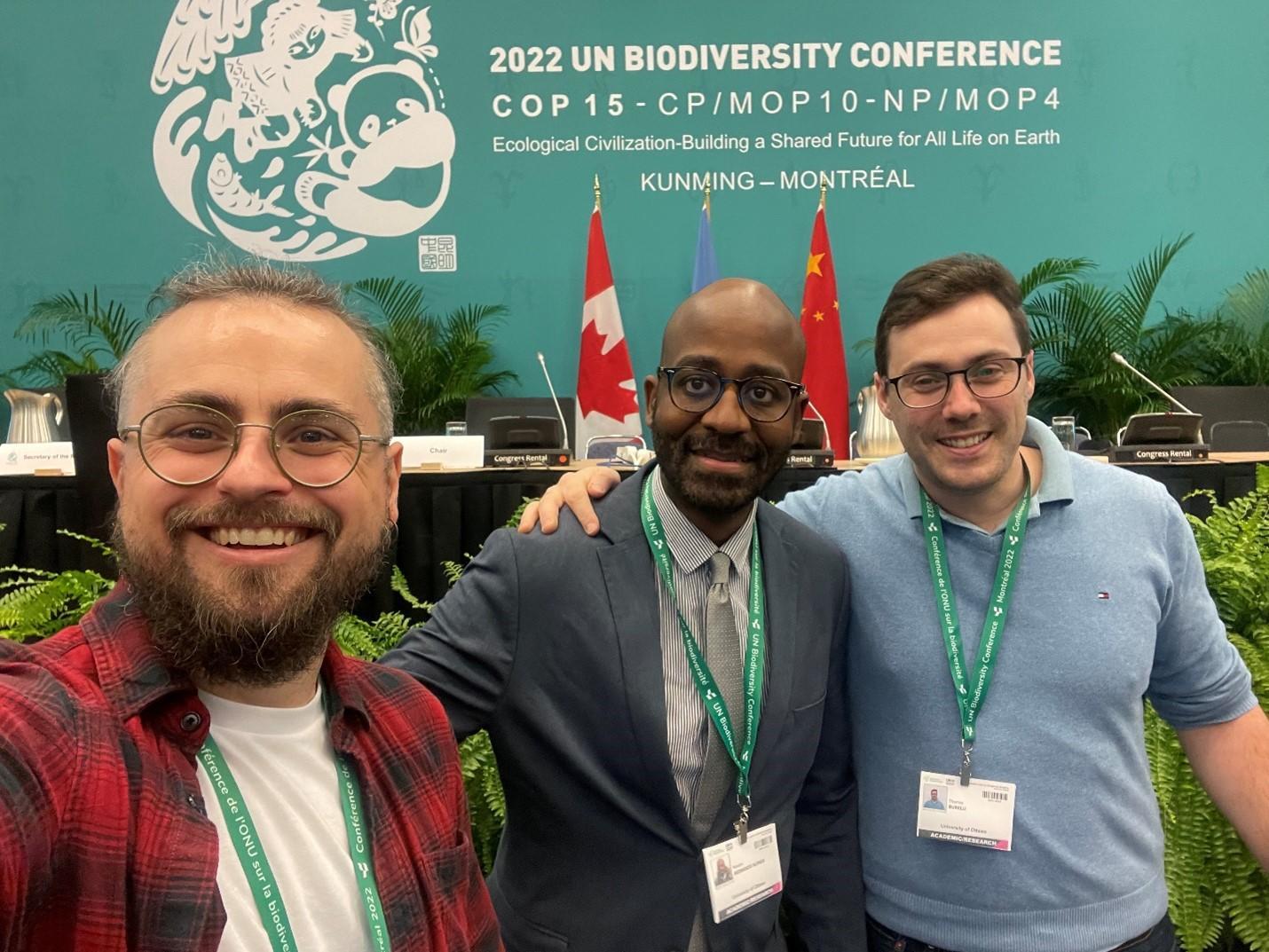 Three members of the CELGS delegation at COP 15  smiling in front the conference's banner
