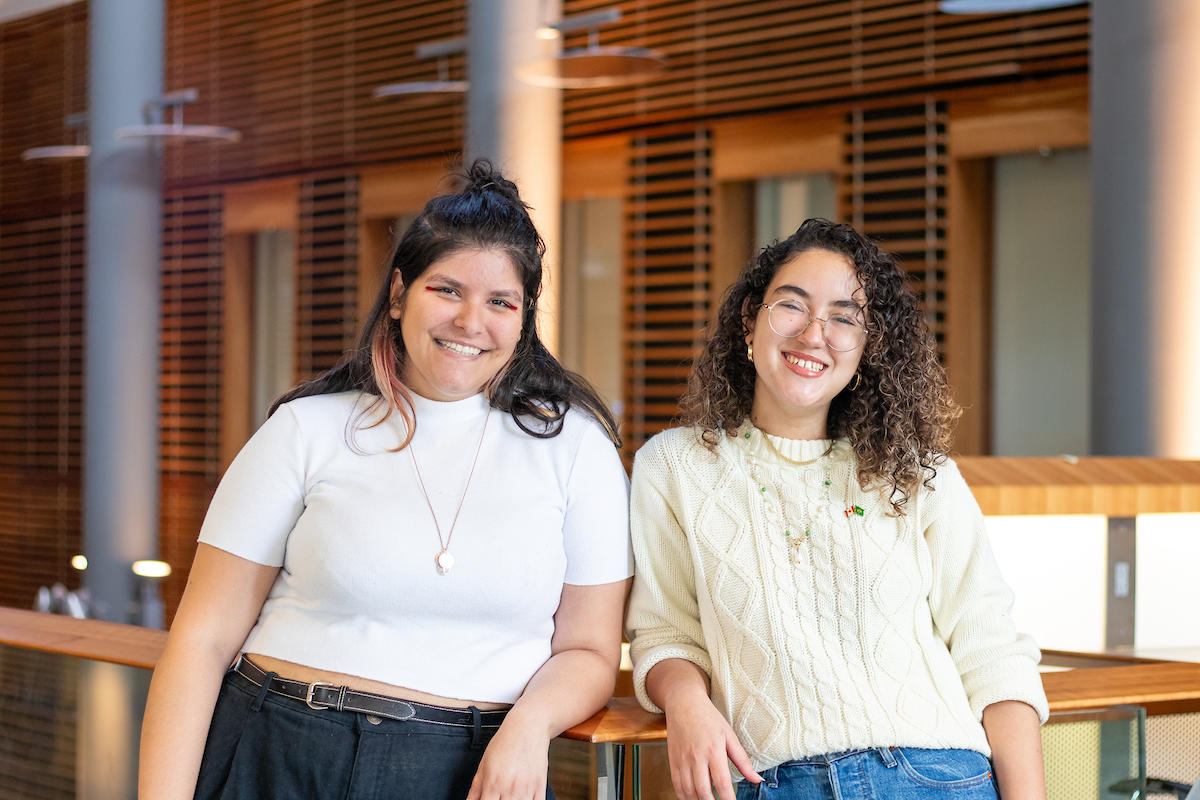 Two students next to one another smiling