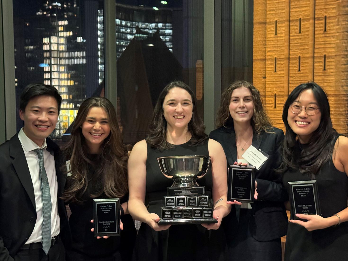 Students holding trophies and plaques at the 2024 Harold G. Fox Intellectual Property Moot