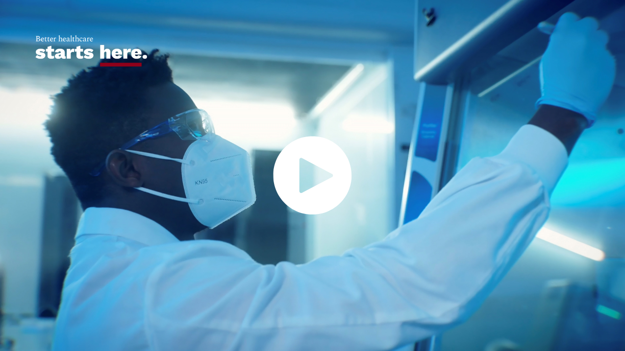 Person writing on a board with a play button overlay, with the tagline Better healthcare starts here.