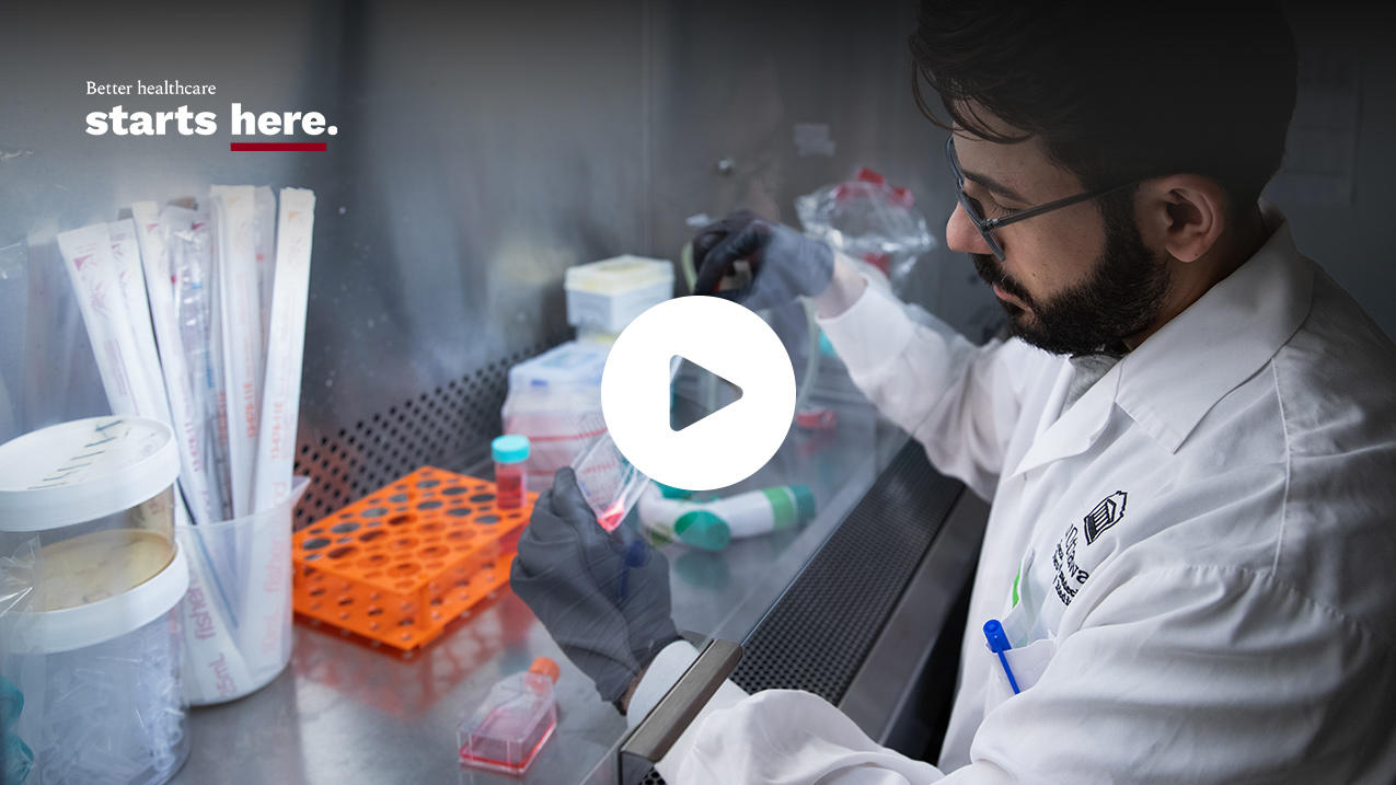 Man in a lab with samples and text Better helathcare starts here with a play icon