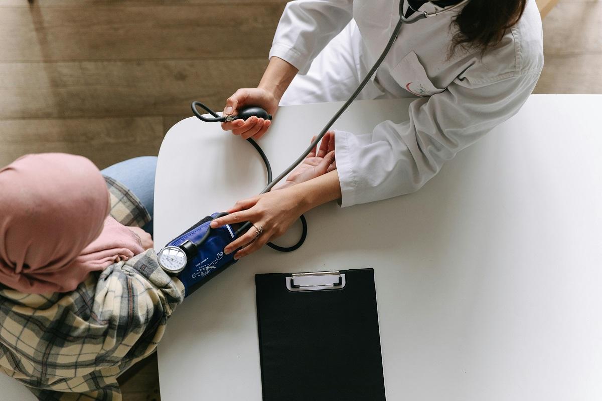 Woman having blood pressure checked by doctor