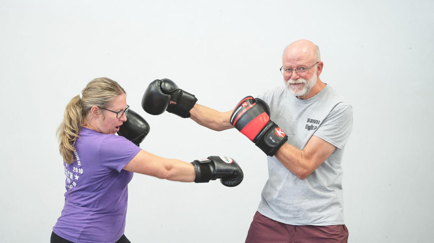 A woman and a man with boxing gloves during a training session on the Boxing4Health programme for people with Parkinson's disease. 